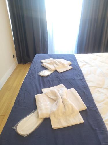 a blue bed with two white towels on it at Batumi Orbi D2, V&O seaview studio in Batumi