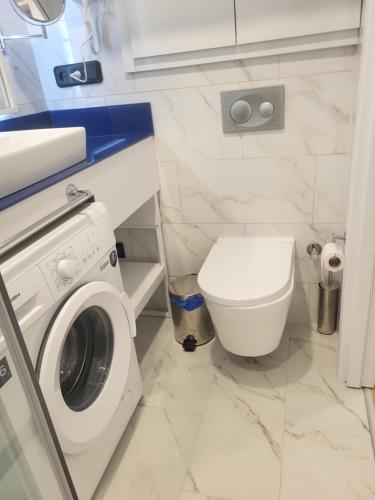 a bathroom with a washing machine and a toilet at Batumi Orbi D2, V&O seaview studio in Batumi