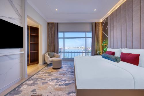 a bedroom with a large bed and a large window at Kempinski Hotel & Resort Sariya Yanbu Red Sea in Yanbu