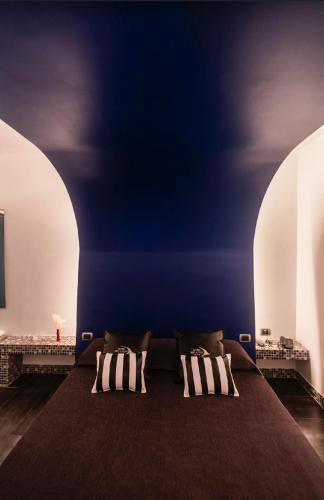 a room with a large bed with three pillows at Hotel Tiro a Volo in Pozzuoli