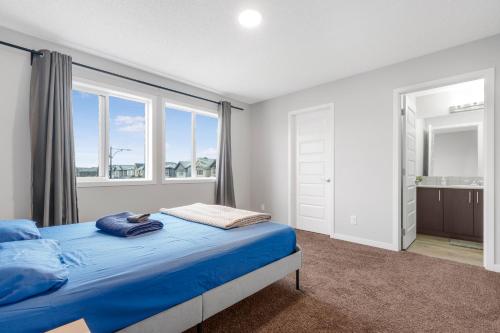 a bedroom with a blue bed and a large window at Private Master Bed Room SPRING in Edmonton