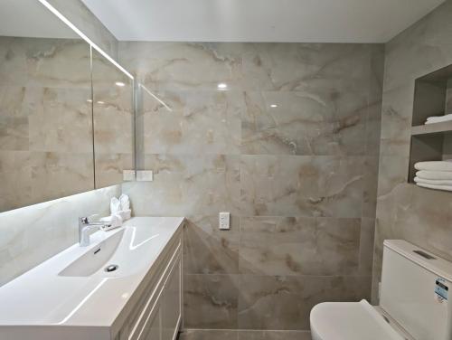 a bathroom with a sink and a toilet at Sunny Nook in Auckland
