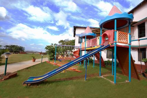 a playground with a slide in front of a house at Brightland Resort & Spa in Mahabaleshwar