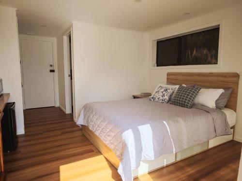 a bedroom with a bed with a television on the wall at Sunny Nook in Auckland