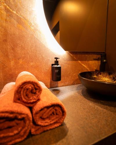 - une serviette sur un comptoir de salle de bains avec une bouteille de savon dans l'établissement Spa Rust Room, à Berstett