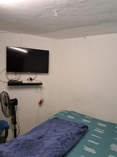 a bedroom with a flat screen tv on a wall at PMB Backpackers Lodge in Pietermaritzburg