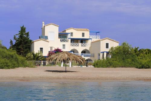 a large white house on the beach near the water at Grand Bleu Anastazia in Porto Heli