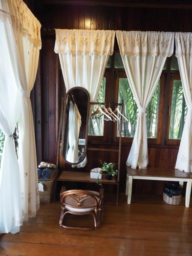 a mirror in a room with curtains and a table at บ้านพระจันทร์เวียน - House of moon phase in Chachoengsao