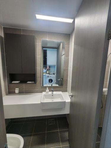a bathroom with a sink and a mirror at Brand New Residence with Family in Busan