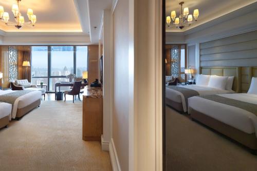 a hotel room with two beds and a living room at The Ritz-Carlton, Chengdu in Chengdu