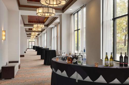 a corridor with a row of tables with bottles of wine at Embassy Suites Chattanooga Hamilton Place in Chattanooga