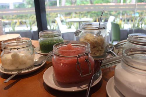 a table with jars of condiments and plates of food at Pomelotel Patra Kuningan Jakarta in Jakarta