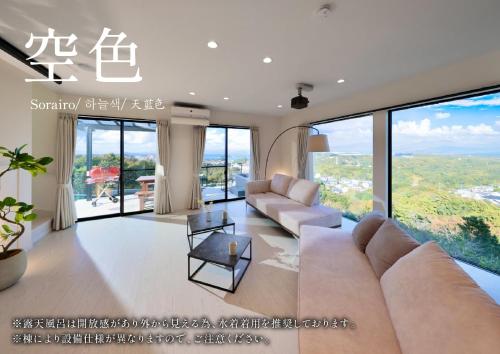 a living room with a couch and some windows at Crystal Besso Shirahama in Shirahama