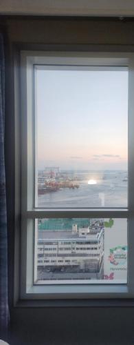 a window in a room with a view of a building at Brand New Residence with Family in Busan