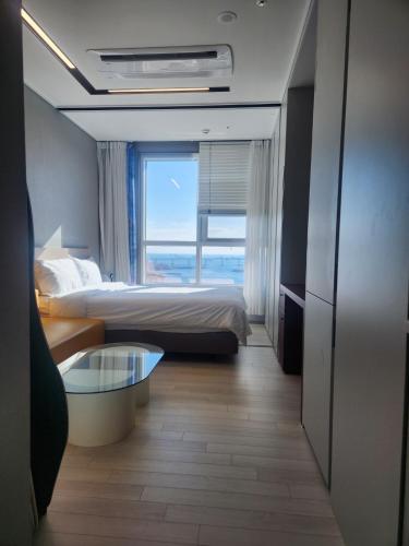 a hotel room with two beds and a glass table at Brand New Residence with Family in Busan