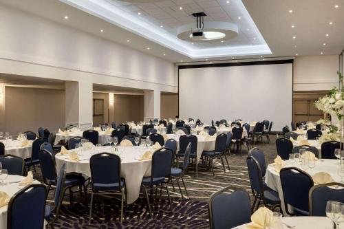 a conference room with tables and chairs and a projection screen at Wyndham Edmonton Hotel and Conference Centre in Edmonton
