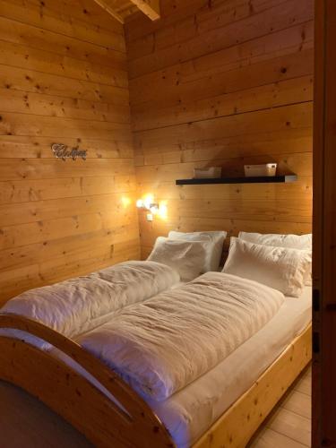 two beds in a room with wooden walls at Luxury Filzmoos Chalet in Filzmoos