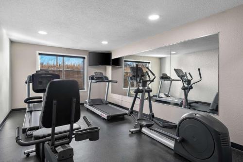 a gym with several tread machines and a mirror at Country Inn & Suites by Radisson, Near The National Sports Center, Coon Rapids, MN in Coon Rapids