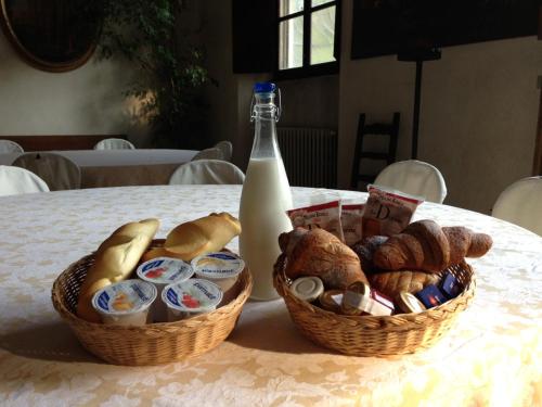 two baskets of bread and a bottle of milk on a table at B&B A Casa Di Andrea in Mantova