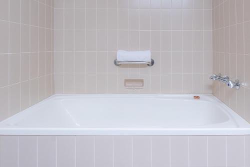 a bath tub in a bathroom with a towel on it at Quality Hotel Ambassador Perth in Perth