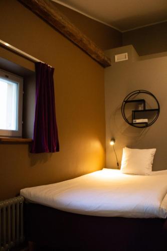 a bedroom with a bed and a window and a mirror at Hellstens Glashus in Stockholm