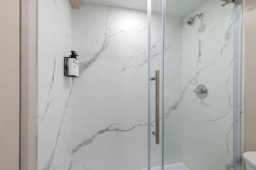 a bathroom with a shower with white marble walls at Wyndham Garden Louisville KY in Louisville