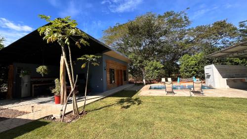 a house with a palm tree in the yard at Apartamento los Guanacastes cerca de Tamarindo con piscina in Santa Cruz