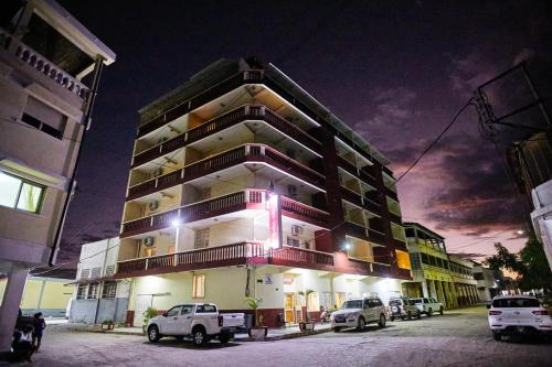 a tall building with cars parked in front of it at Anjary Hotel Mahajanga in Mahajanga