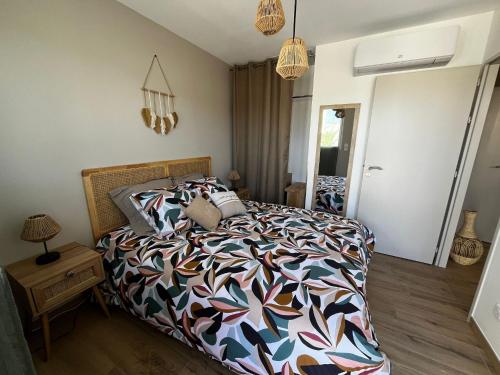 une chambre avec un lit avec une couette colorée dans l'établissement Sun Oasis Les Tamaris, à Bretignolles-sur-Mer