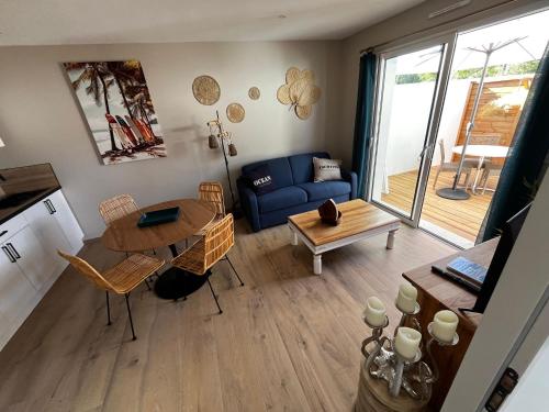 un salon avec un canapé bleu et une table dans l'établissement Sun Oasis Les Tamaris, à Bretignolles-sur-Mer