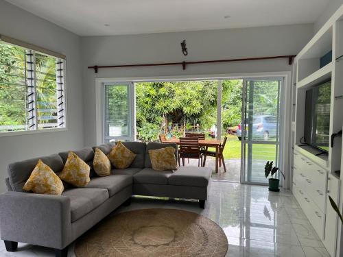 a living room with a couch and a table at Drydens Creek Retreat in Ngatangiia