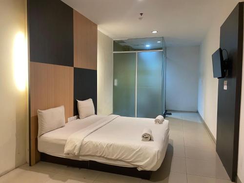 a bedroom with a bed and a television in it at Baloi View Apartment in Nagoya