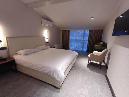 a hotel room with a bed and a chair at Old Avenue Hotel in Gyumri