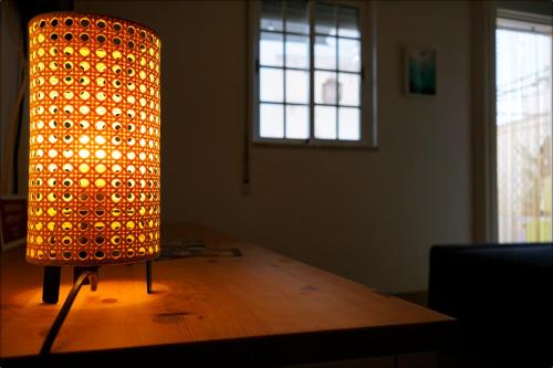a lit up lamp sitting on top of a wooden table at Casa da Praia - Manta Rota in Manta Rota