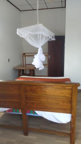 a wooden bed with a white teddy bear on it at Sunshine Guest in Madihe East