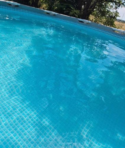 une grande piscine avec de l'eau bleue dans l'établissement Appartement tout équipé 2 chambres + jardin, à Saix