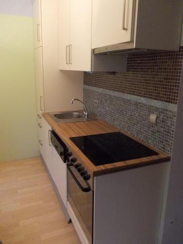 a kitchen with white cabinets and a sink and a stove at Fewo-Rosenheim im Zentrum mit kostenlosem Parkplatz in Rosenheim