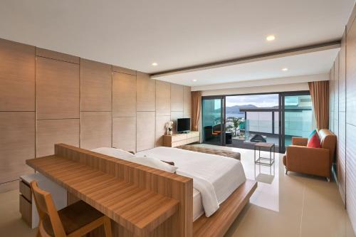 a bedroom with a bed and a desk and a television at Patong Bay Hill in Patong Beach