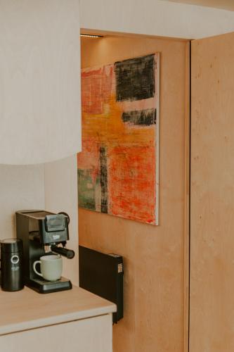 a kitchen with a coffee maker and a painting on the wall at Błogostan in Jodłów