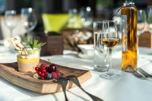 a table with a plate of food and a glass of wine at Superior Hotel Nidwaldnerhof in Beckenried