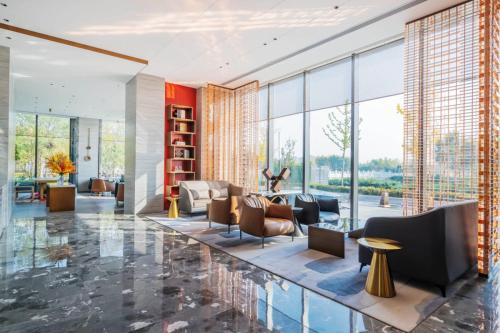 a living room with a lot of windows at Radisson Hotel, Beijing DaXing Airport in Beijing