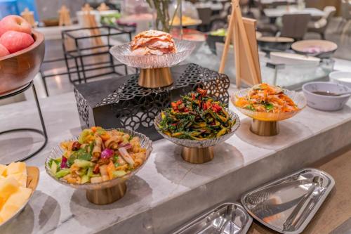 a table topped with different types of food in bowls at Radisson Hotel, Beijing DaXing Airport in Beijing