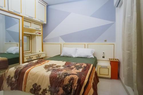 a small bedroom with a bed and a mirror at Vj Sweethome Syariah Near GOR Turida in Tjakranegara