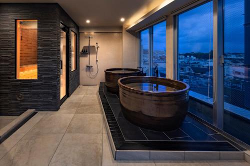 a bathroom with two tubs and a window at The SAUNA Escape Shibuya in Tokyo