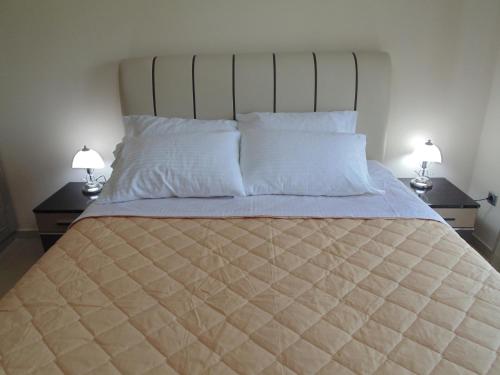 uma cama grande com dois candeeiros em duas mesas em Palaiologou Panorama Apartments em Mantamádos