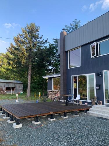a house with a wooden deck in front of it at スヴァールバルレジデンス in Minamifurano