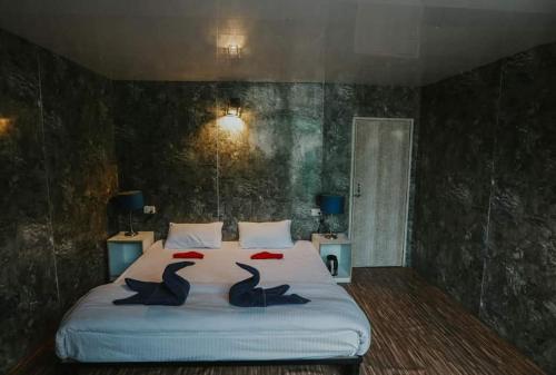 two birds sitting on a bed in a bedroom at Soma Caves in Kulu