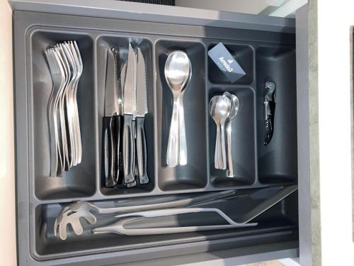 un tiroir rempli d'ustensiles dans un plateau noir dans l'établissement d.s house mare & sentieri, à Rapallo