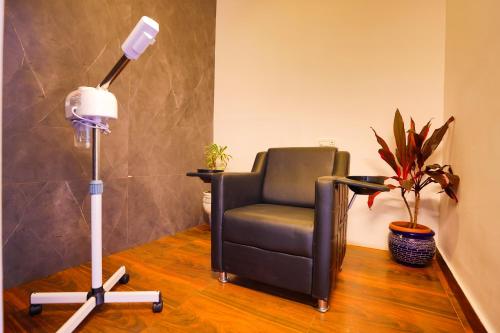 a room with a black chair and a floor lamp at The Grand Retreat - Chikmagalur in Chikmagalūr