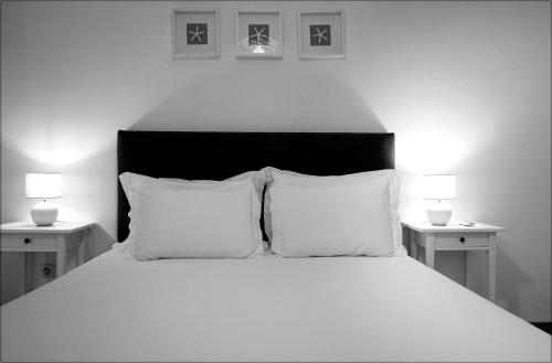 a bedroom with a white bed with two night stands at Casa da Praia - Manta Rota in Manta Rota